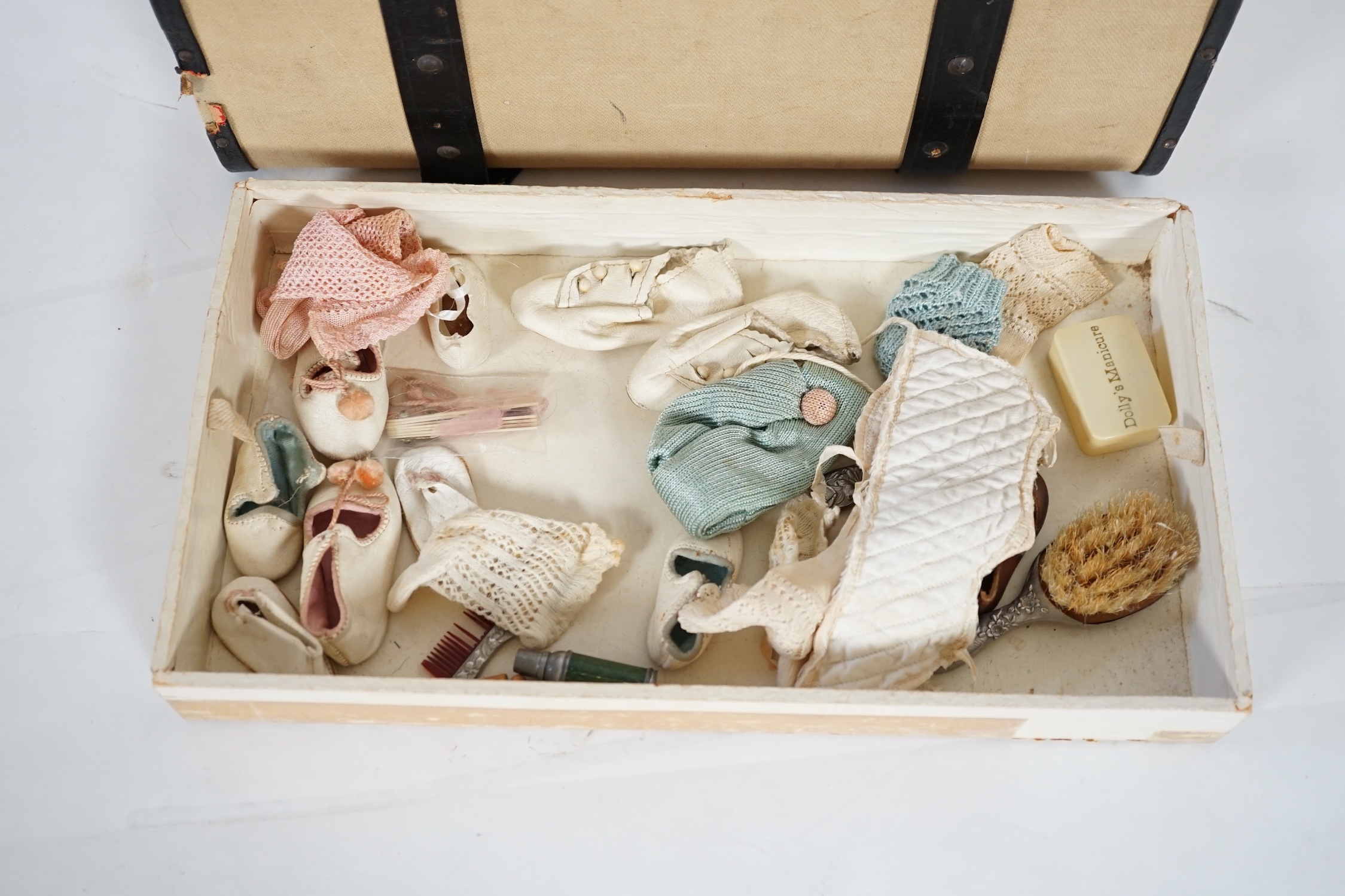 A doll's trunk with assorted vintage clothes, shoes and doll's accessories